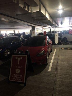 A Tesla Model 3 parking in a supercharger stall without using the charger.