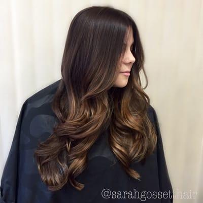 Warm chocolate color fading into slightly lighter ends, haircut and glam waves.