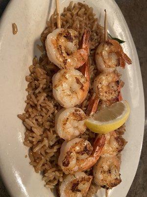 Grilled shrimp served on a bed of rice.