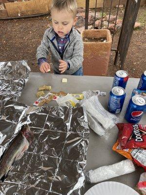 Little one helps stuff the fish with butter S&P and garlic