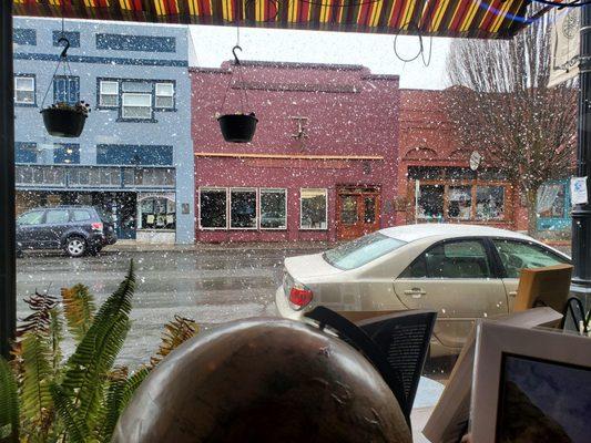 Cozying up with a book during a snowfall at Zephyr bookstore and coffee shop. View from the window.