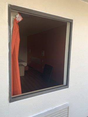 A room with a broken out window.