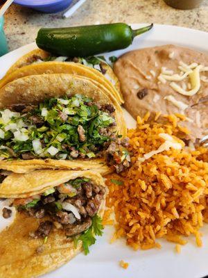 3 Carne asada taco dinner with cilantro and onion on corn tortillas, plus a raw jalapeño