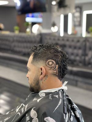 Fade Mohawk with a back graphic .