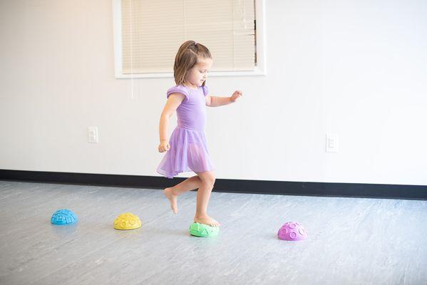 Preschoolers develop their balance and coordination using our balance dots. We dance bare foot to increase proprioception in little dancers