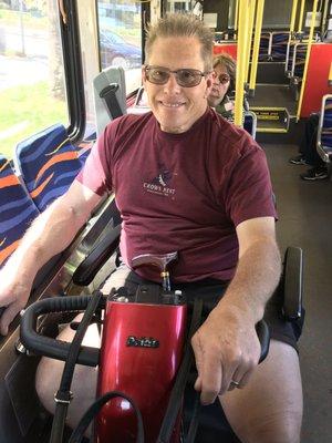 "The Boss"enjoying a ride on the bus with his loaner scooter. Thank you alpine medical.