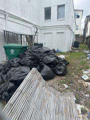 The back of the salon with piles of trash that needs to be removed.