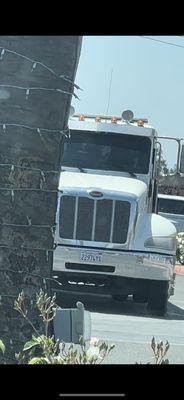 The license plate of the truck and drivers inside