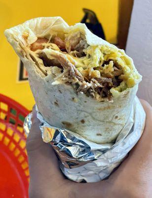 Brisket Burrito, shredded brisket, cilantro-lime rice, black beans, guacamole, cheese, pico de gallo, and garlic sauce in a flour tortilla