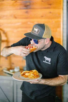 Man enjoying a delicious hot dog with toppings