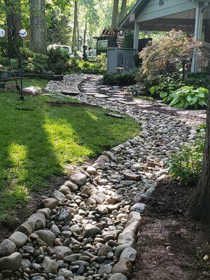 Great dry creek bed enhancing the natural look of our client's backyard.