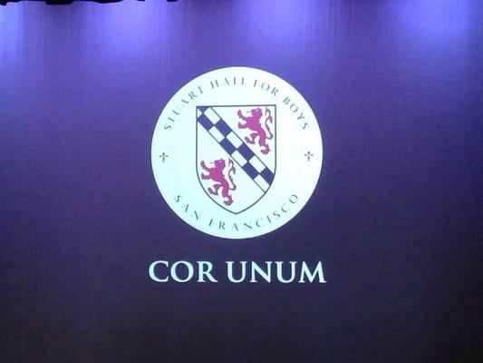 SHB Crest with 2012-2013 school motto "Cor Unum," meaning "one heart".