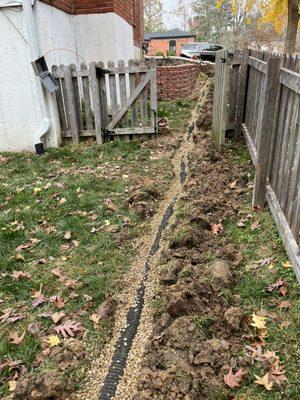 French drain in ground before backfilling and laying grass seed