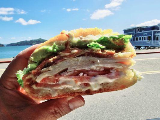 The All American - Turkey, Bacon, Avocado, tomato, lettuce, onion, mayo, mustard inside a fresh toasted Acme roll