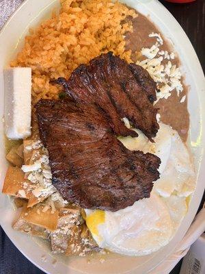 Carne asada chilaquiles with egg over easy verde sauce and rice and beans