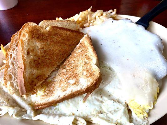 Chicken fried steak, smothered with gravy, over medium eggs, hashbrowns, and toast! Delightful!