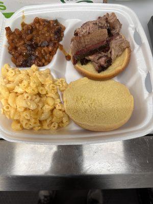 Smoked brisket sandwich with smoked baked beans and macaroni with homemade cheese sauce