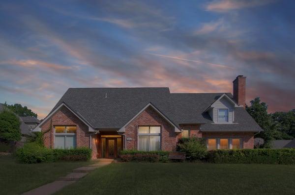 The abundance of windows in this South Tulsa home is demonstrated here with glow of warm light at dusk...