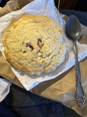 Cranberry scone next to a tablespoon for perspective.