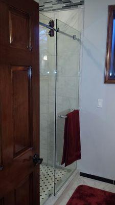 Barn door style heavy glass shower door with polished chrome hardware