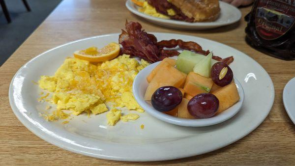 Egg and bacon plate with fruit (scrambled with cheese)