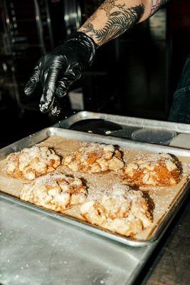 Our pastry chef Toni dusting these Apple Fritters with a nice layer of sugar.