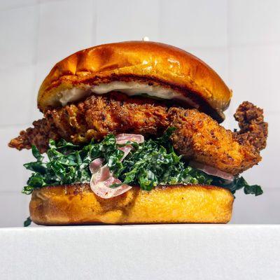 Fried Chicken with House-Made Pickles, Tahini Ranch, Pickled Onions, and Kale Slaw on a Toasted Brioche Bun.