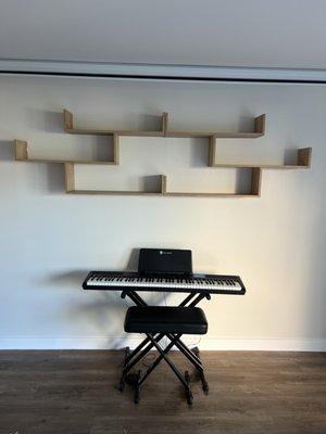 Book shelf mounted above piano.