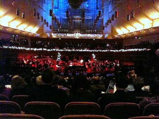 Concert goers are coming in, finding their seats, orchestra warming up