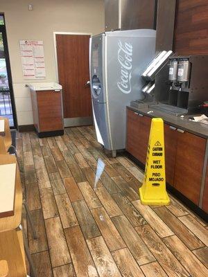 1. Have someone mop up the water. 2. ITS BEEN MONTHS GET THE SODA MACHINE LEAK FIXED!!!!!!