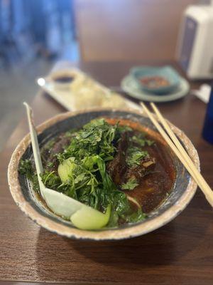 roasted pork rib noodle soup with pan fried bao in the background