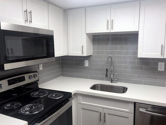 Newly renovated apartments with quartz counters and glass tile backsplash.