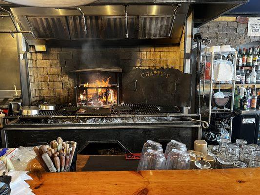 Wood fired grill behind bar