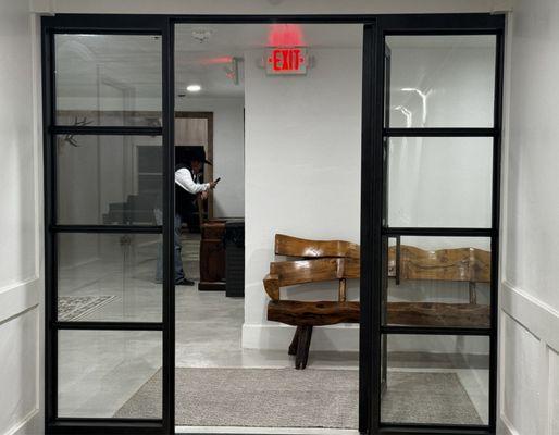 Black steel doors leading from guest hallway into reception lobby area.