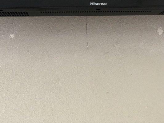 Marks and holes on the wall, where they placed a television bracket and then moved it. Needs repainting.