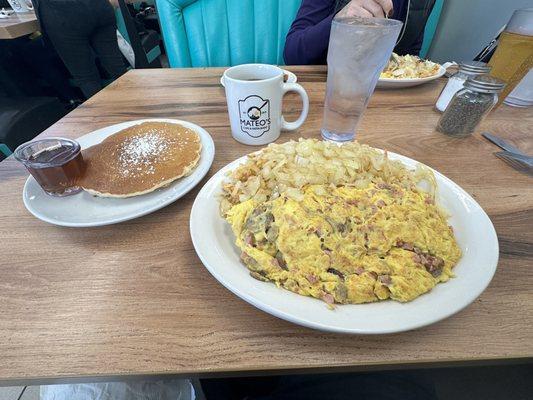 Meat omelette with mushrooms, hash browns with grilled onions and pancakes.