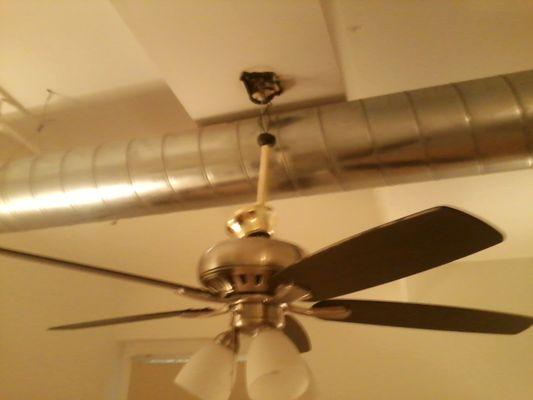 Ceiling fan hanging loose by wires.