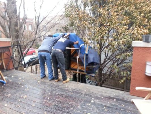 Hoisting a grand piano up to the second floor using the garage roof deck - a tight spot in the City of Chicago!