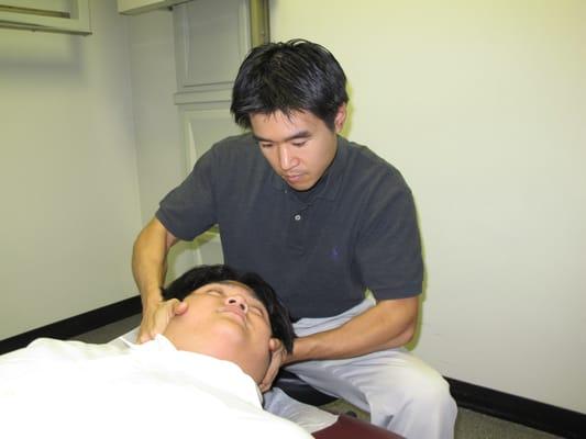 Dr. Charles Feng performs a gentle manipulation of the cervical vertebrae.