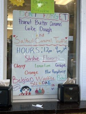 Sign in Ron's window with summer menus and new ice cream flavors