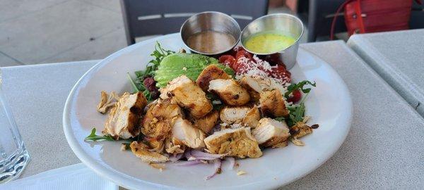 Arugula salad with grilled chicken, lemon herb and Italian dressing on the side