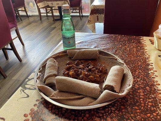 Awaze Tibs with a bottle of San Pellegrino sparkling water.