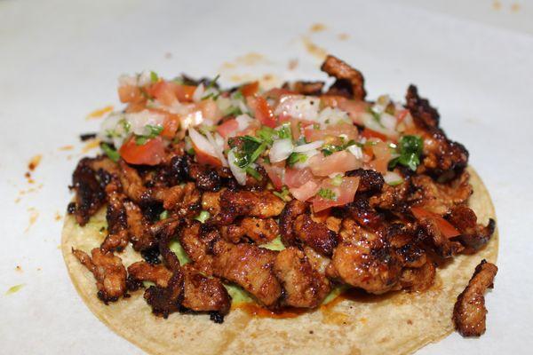 Pastor Taco ( Marinated Pork with Housemade Guacamole & Housemade Pico de Gallo  in a Large Corn Tortilla.