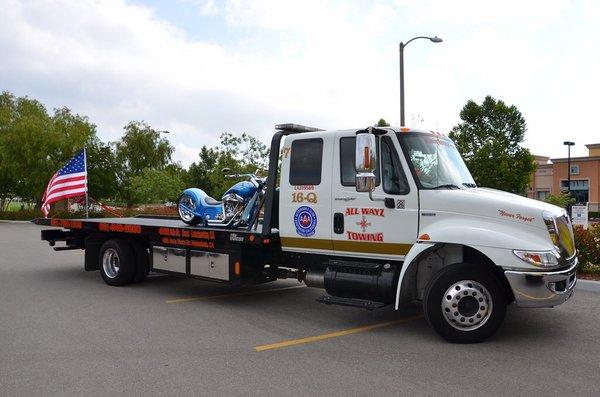 Flatbed towing a motorcycle.