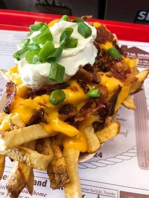 Loaded fries with bacon, cheese sauce, sour cream and green onions