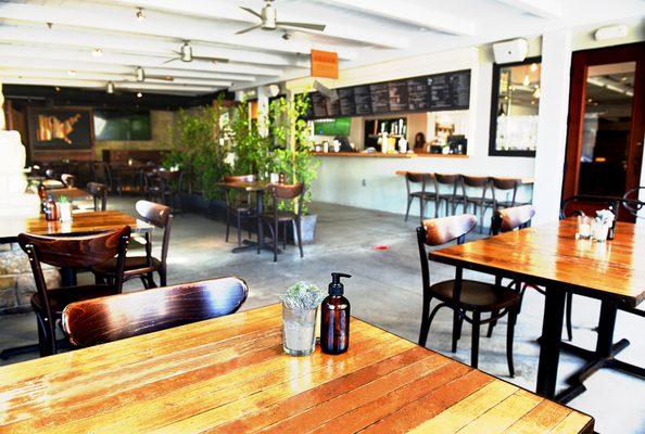 View of the outdoor patio seating and menu board at Benchmark Eatery