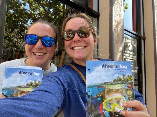 My friend and I holding up our dive logs, proud to be certified following our last dive!