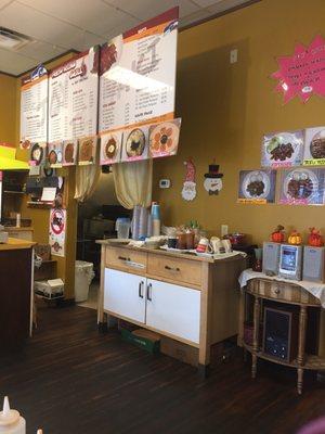 The cashier, entrance to the kitchen, and hanging menu area.