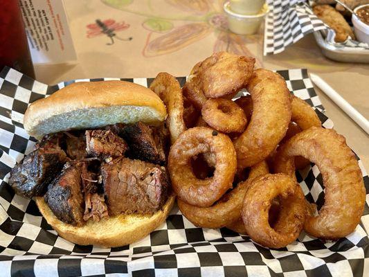 The burnt end sandwich with a side of onion rings.