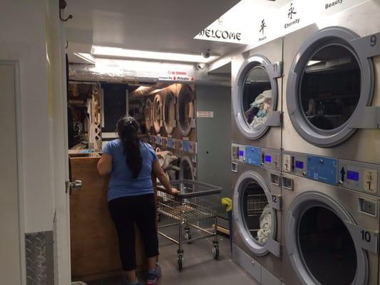 Dryers along the wall and in-house laundry service in the back